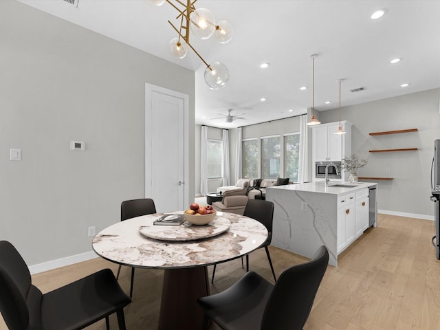 dining room with sink, ceiling fan, and light hardwood / wood-style flooring