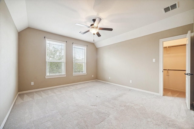 carpeted empty room with ceiling fan and lofted ceiling