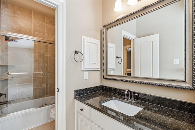 full bathroom with tiled shower / bath, vanity, and toilet