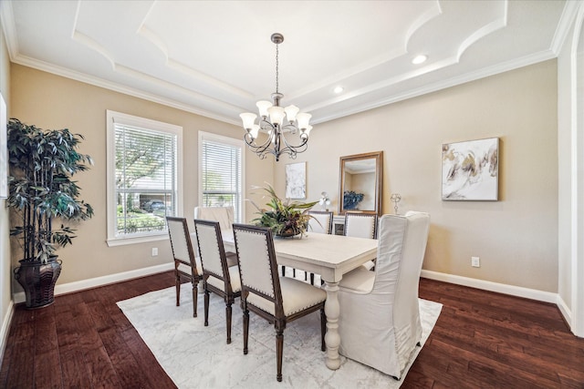 dining room featuring an inviting chandelier, a tray ceiling, dark wood-type flooring, and crown molding