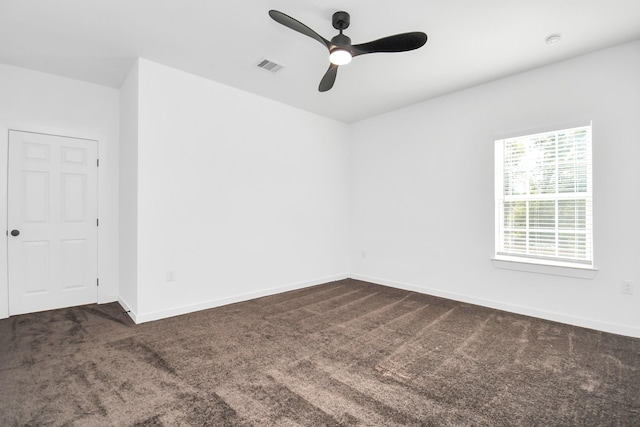 unfurnished room featuring dark carpet and ceiling fan