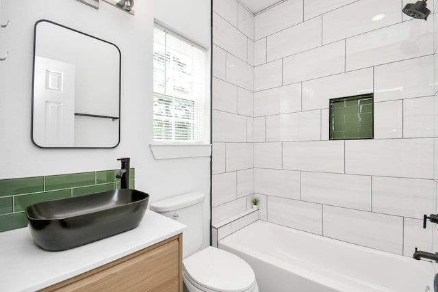 full bathroom featuring vanity, toilet, tiled shower / bath combo, and decorative backsplash