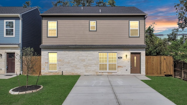 view of front facade featuring a lawn and a patio