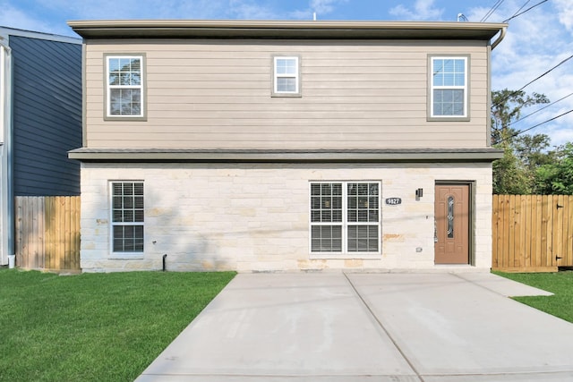 rear view of property featuring a lawn and a patio area