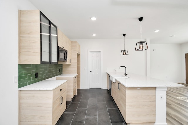 kitchen with tasteful backsplash, sink, decorative light fixtures, and light brown cabinets