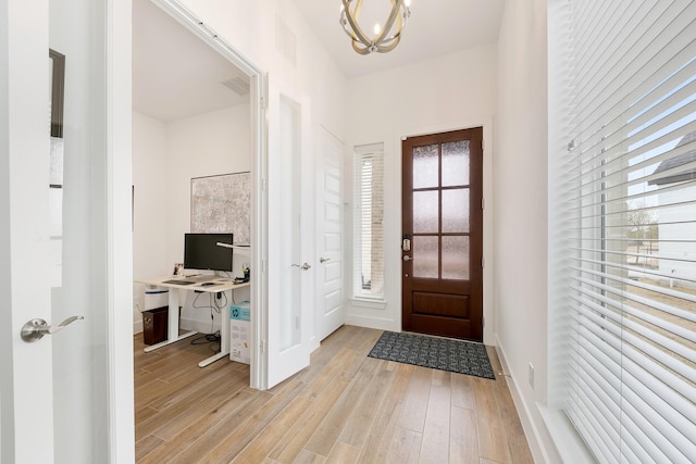 entrance foyer with a chandelier and light hardwood / wood-style flooring