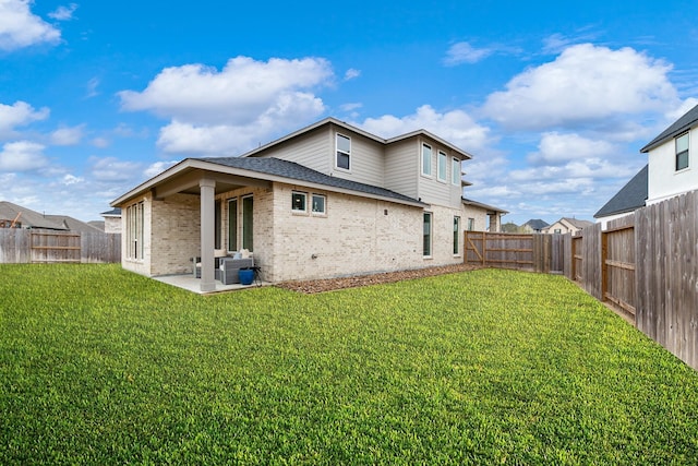 rear view of property with a lawn and a patio area