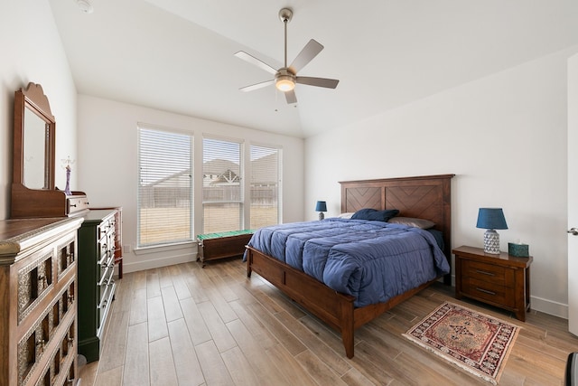 bedroom featuring ceiling fan, lofted ceiling, and light wood-type flooring