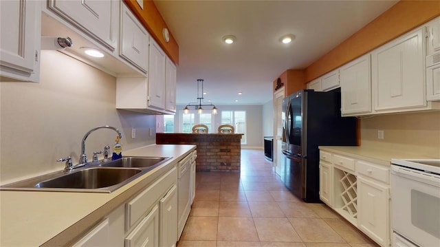 kitchen featuring hanging light fixtures, white appliances, sink, and white cabinets