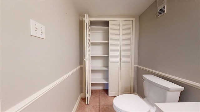 bathroom featuring toilet and tile patterned flooring