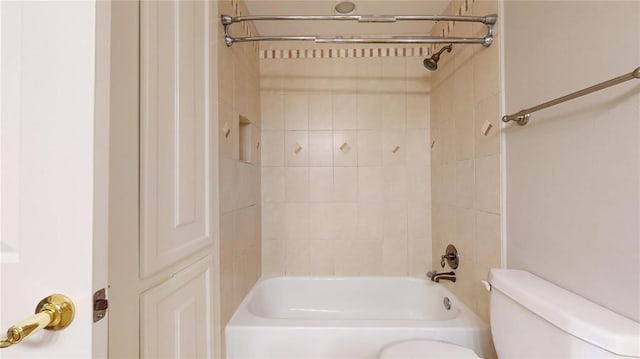 bathroom featuring tiled shower / bath combo and toilet