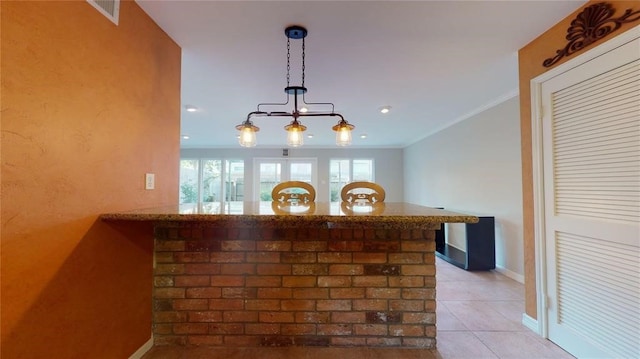 bar with ornamental molding, hanging light fixtures, and light tile patterned floors