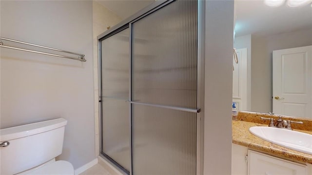 bathroom featuring vanity, toilet, and an enclosed shower