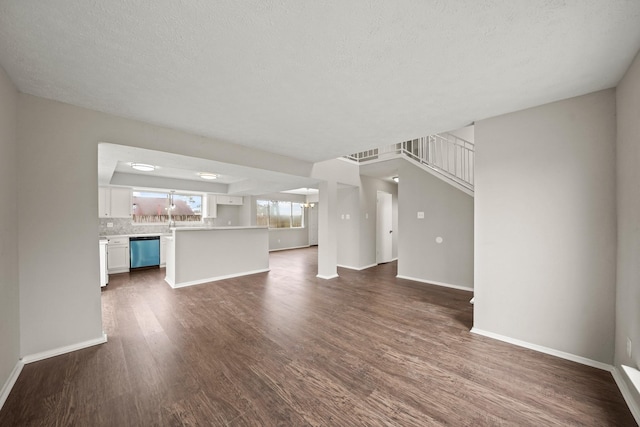 unfurnished living room featuring dark hardwood / wood-style flooring and a textured ceiling