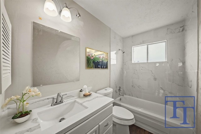 full bathroom featuring vanity, a textured ceiling, toilet, and tiled shower / bath