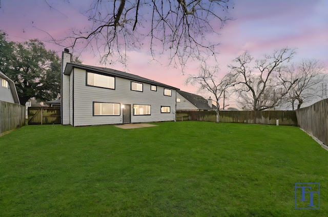 back house at dusk with a yard