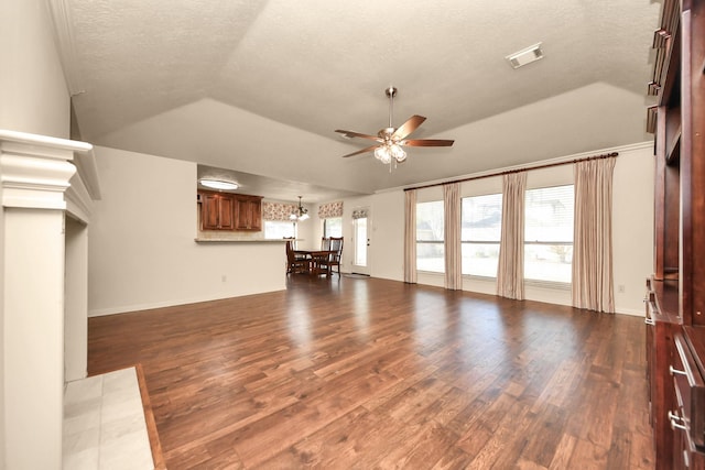 unfurnished living room featuring dark hardwood / wood-style flooring, ceiling fan with notable chandelier, vaulted ceiling, and a textured ceiling