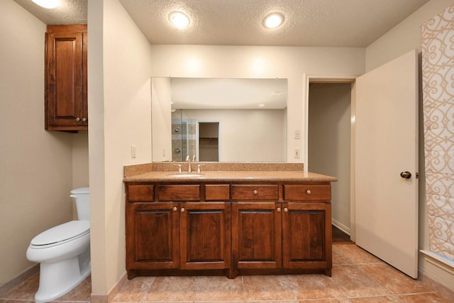 bathroom with vanity, a textured ceiling, and toilet