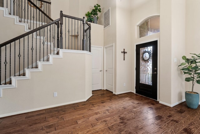 foyer featuring a healthy amount of sunlight, dark hardwood / wood-style floors, and a high ceiling