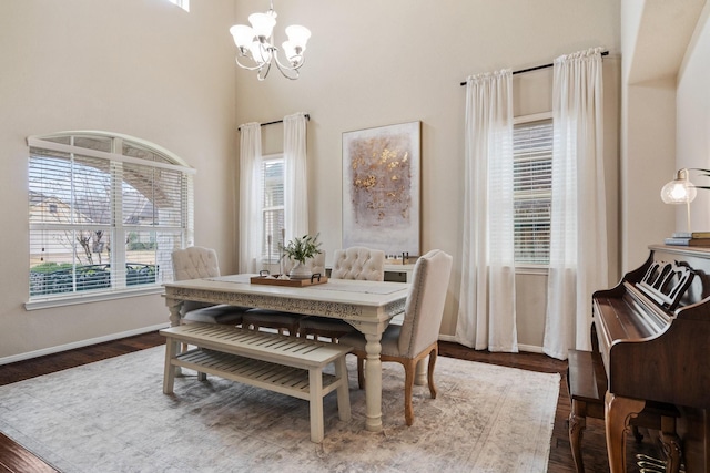 dining area featuring dark hardwood / wood-style flooring and an inviting chandelier