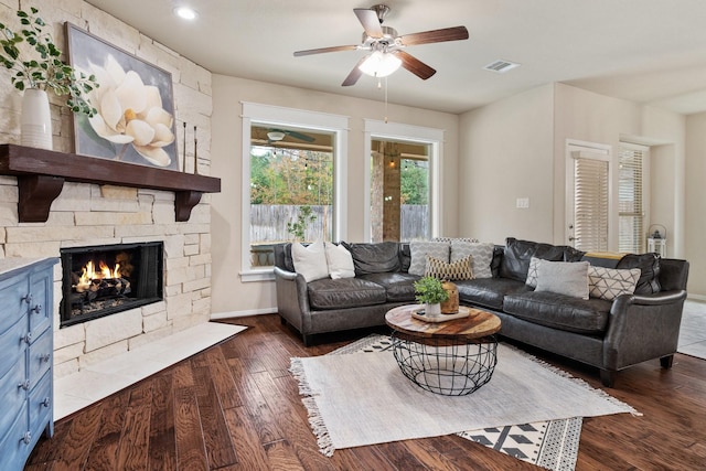 living room featuring ceiling fan, a fireplace, and dark hardwood / wood-style flooring