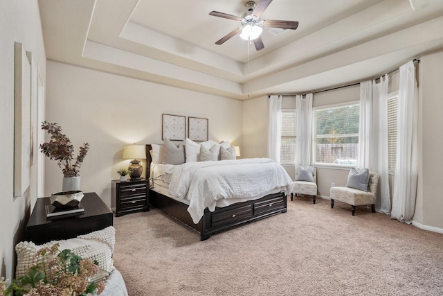 bedroom with ceiling fan, a raised ceiling, and carpet