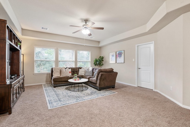 carpeted living room featuring a tray ceiling and ceiling fan