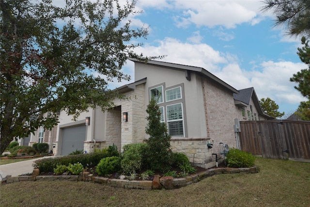 view of property exterior with an attached garage, fence, concrete driveway, stone siding, and stucco siding