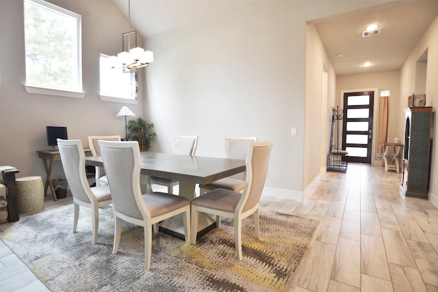 dining area featuring baseboards, light wood finished floors, visible vents, and an inviting chandelier