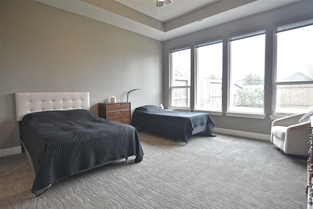 carpeted bedroom featuring multiple windows and baseboards