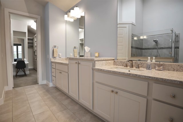 bathroom with a spacious closet, a stall shower, vaulted ceiling, vanity, and tile patterned flooring