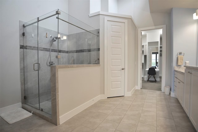 full bathroom with a shower stall, baseboards, and vanity