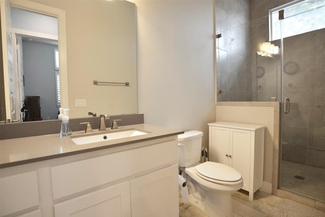 bathroom featuring a stall shower, vanity, and toilet