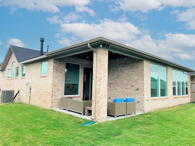 view of home's exterior featuring brick siding, a patio, a lawn, central AC unit, and an outdoor hangout area