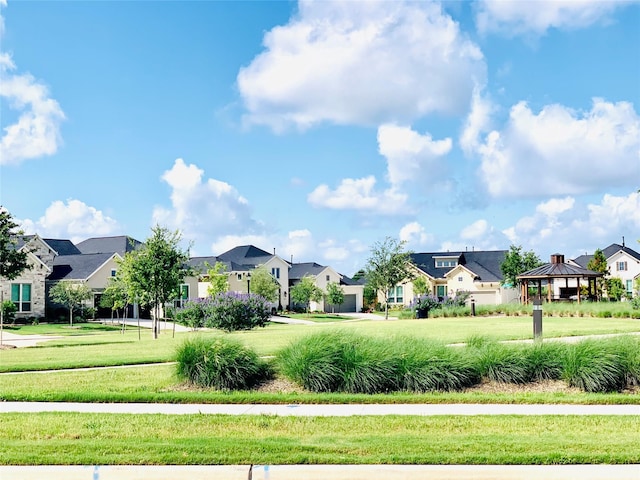 view of property's community with a yard, a gazebo, and a residential view