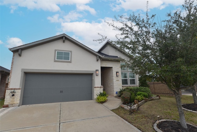 view of front facade with stone siding, concrete driveway, a garage, and stucco siding