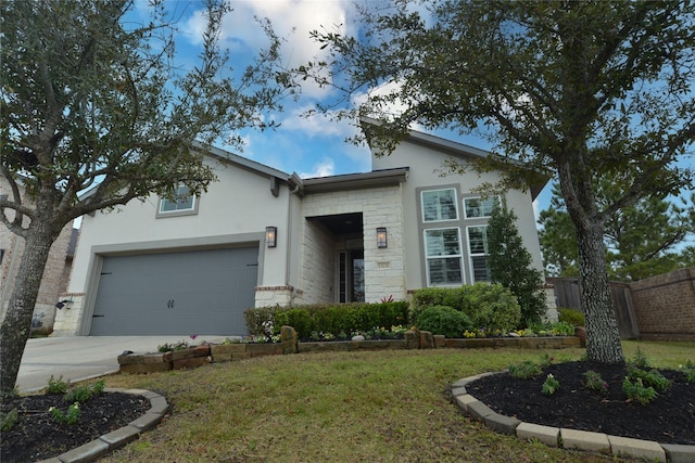 view of front of house featuring stone siding, fence, concrete driveway, and stucco siding