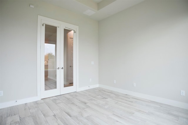 unfurnished room featuring light wood-type flooring, baseboards, and french doors