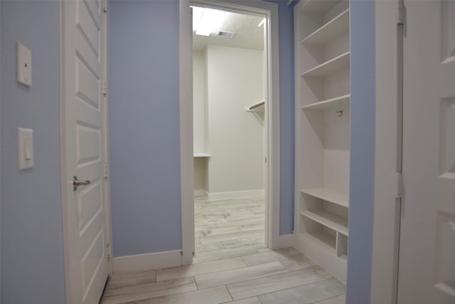 interior space with wood finish floors, visible vents, and baseboards