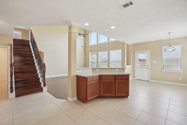 kitchen featuring light tile patterned floors, ceiling fan, visible vents, and decorative light fixtures