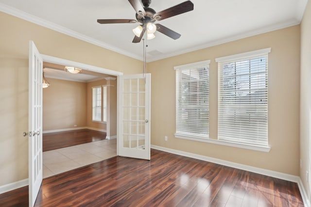 spare room featuring a ceiling fan, baseboards, ornamental molding, french doors, and dark wood finished floors