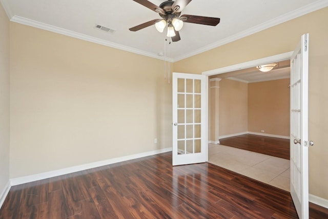 empty room featuring french doors, visible vents, dark wood-type flooring, ornamental molding, and baseboards