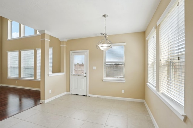 entrance foyer featuring a healthy amount of sunlight, light tile patterned floors, and baseboards