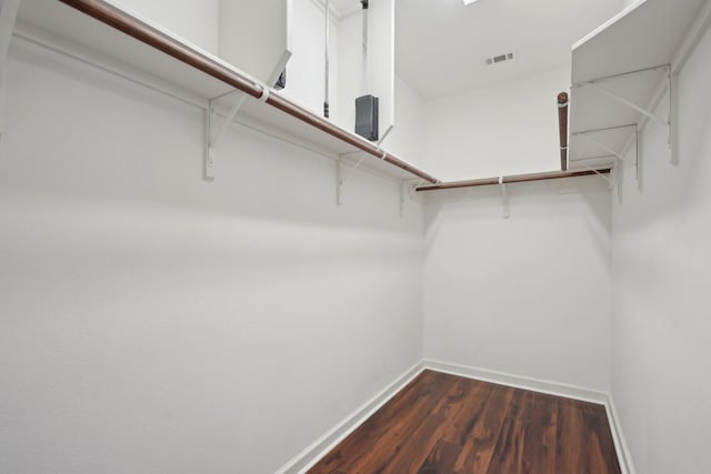 spacious closet with dark wood-style flooring and visible vents