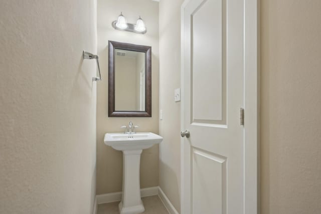 bathroom with a sink and baseboards