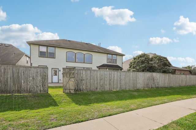 back of property featuring a yard and fence