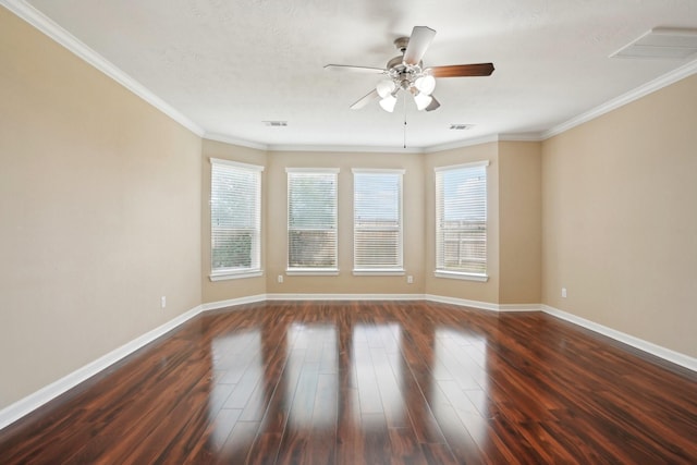 spare room featuring dark wood-style floors, visible vents, ornamental molding, a ceiling fan, and baseboards