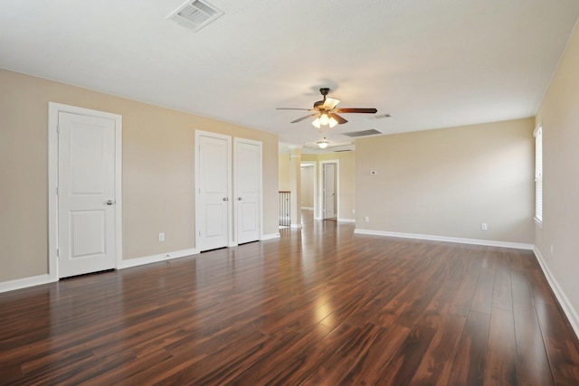 spare room featuring dark wood-style floors, visible vents, and baseboards