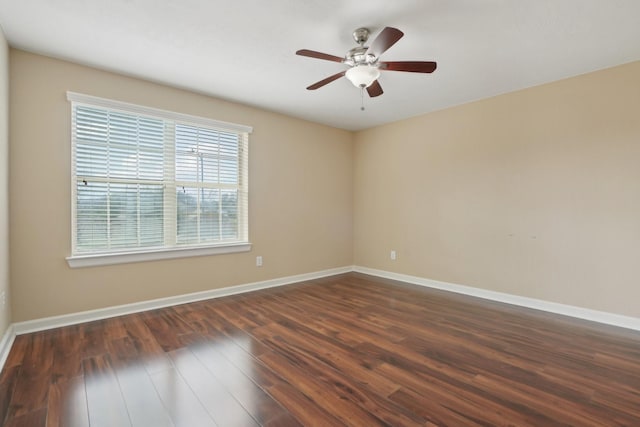 spare room with dark wood-style floors, ceiling fan, and baseboards