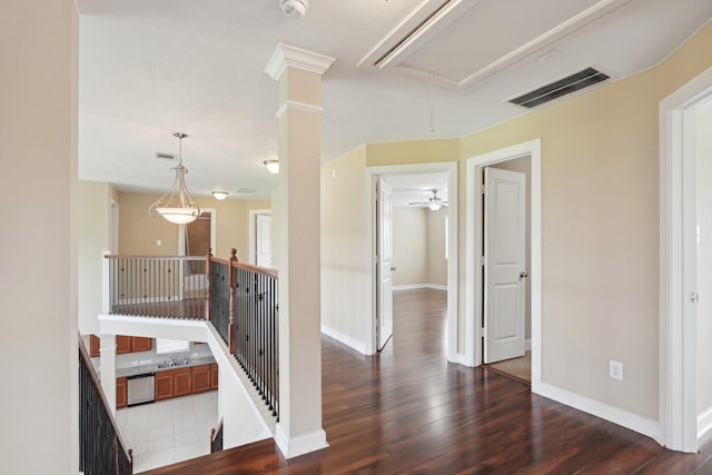 corridor with attic access, baseboards, visible vents, and dark wood-type flooring